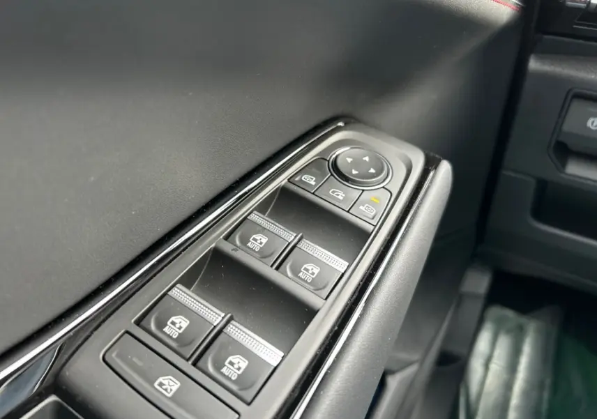 Gros plan sur les commandes des vitres électriques côté conducteur de la Renault Rafale noire esprit Alpine 2025.