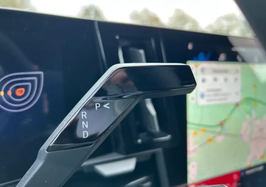 Le levier de vitesses automatique noir de la Renault Rafale hybride, avec écran tactile de navigation en arrière-plan.