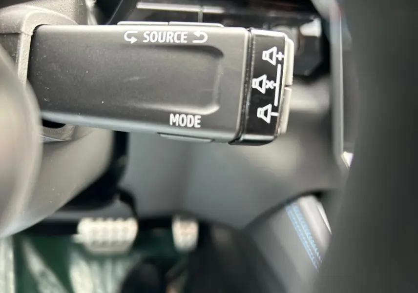 Gros plan sur la commande au volant noir avec marquages blancs dans l'habitacle du Renault Rafale noir 2025.