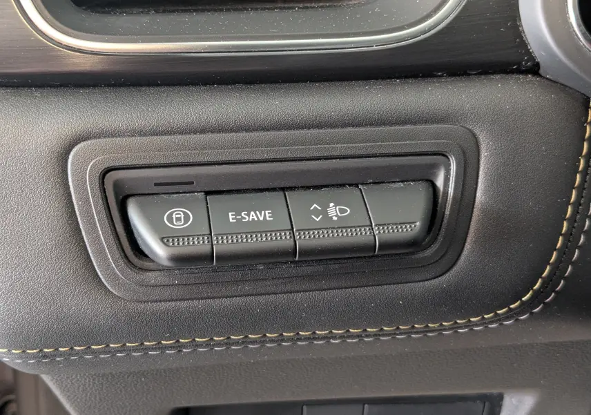 Gros plan sur les boutons de commande noirs avec surpiqûres beiges dans l’habitacle du Renault Symbioz E-Tech Full Hybrid 2025.