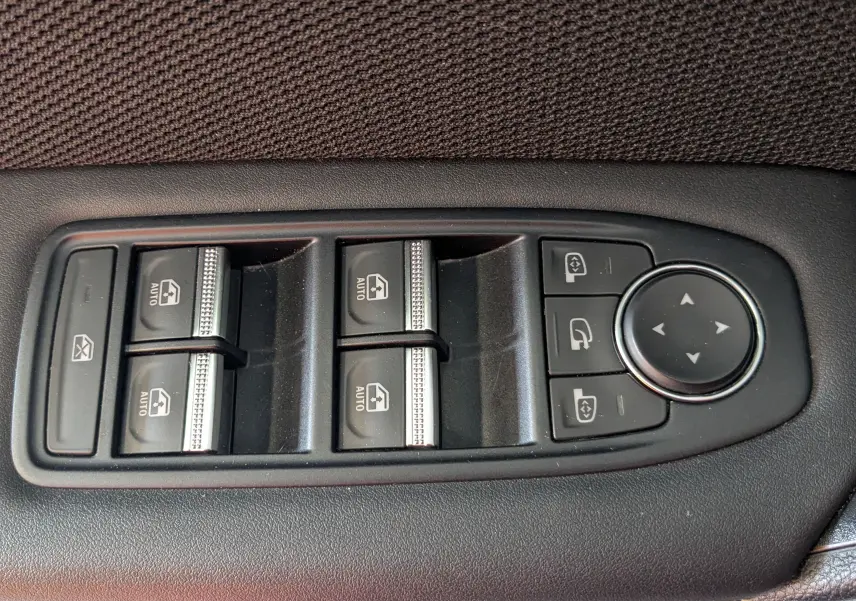 Panneau de commandes des vitres électriques et rétroviseurs sur portière intérieure en tissu gris du Renault Symbioz E-Tech Hybrid 2025.