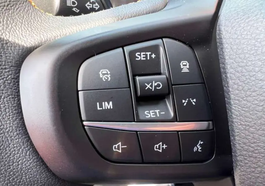 Gros plan sur les commandes multifonctions noires du volant du Ford Ranger Wildtrak Plus 2025.