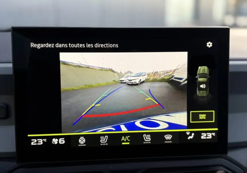 Écran de caméra de recul montrant l'arrière du Dacia Bigster noir nacré avec lignes de guidage colorées.
