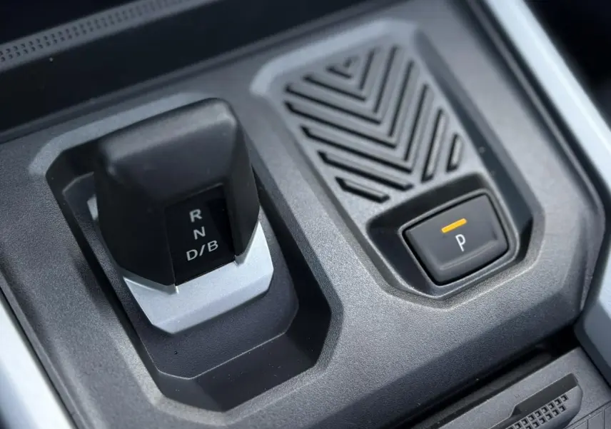 Gros plan sur la commande de boîte automatique et bouton de parking du Dacia Bigster 1.8 Hybrid noir nacré.
