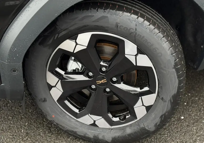 Gros plan sur la jante alliage 18'' bicolore noire et argent du Dacia Bigster Noir Nacré, avec pneu Continental EcoContact 6.0.