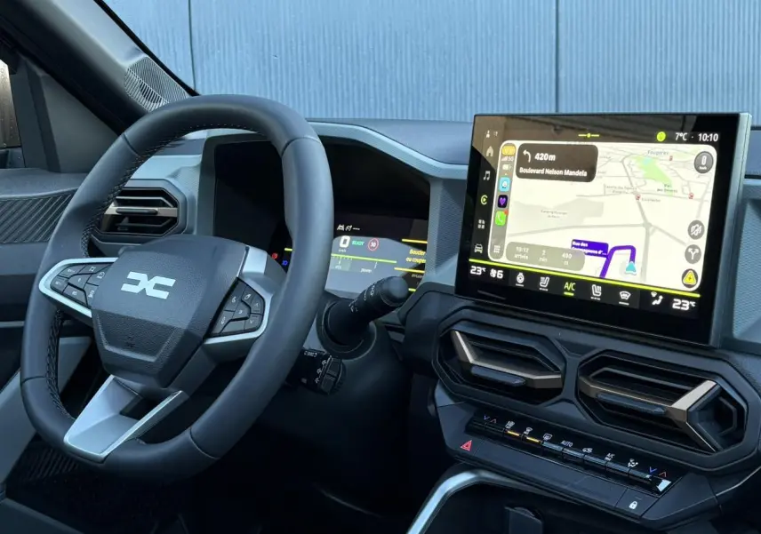 Vue intérieure du tableau de bord et volant noir du Dacia Bigster 2026 avec écran tactile de navigation et commandes intégrées.