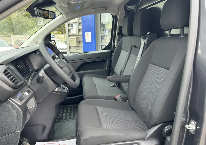 Intérieur du Citroën Jumpy Fourgon gris acier 2025, vue côté conducteur sur les sièges tissu et tableau de bord moderne.