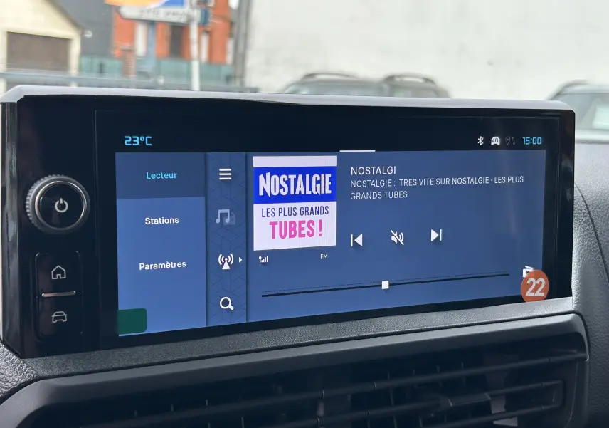 Écran tactile central du tableau de bord du Citroën Jumpy Fourgon gris acier affichant la radio FM Nostalgie.