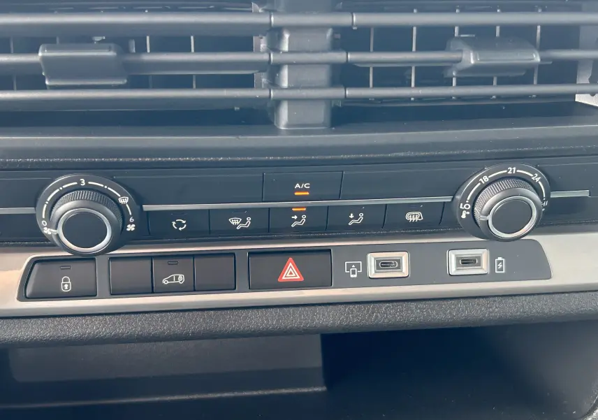 Gros plan sur la console centrale du Citroën Jumpy Fourgon gris acier, montrant les commandes de climatisation et ports USB.