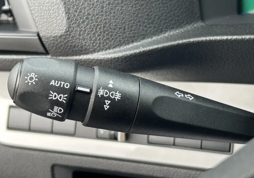 Gros plan sur la commande des phares et clignotants du Citroën Jumpy Fourgon gris acier, intérieur noir texturé.