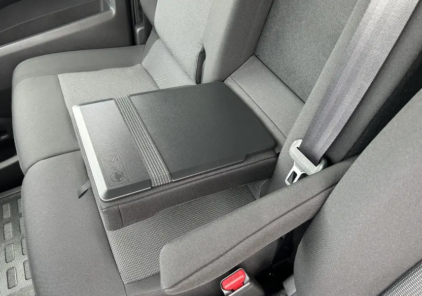 Gros plan sur la banquette avant grise du Citroën Jumpy Fourgon 2025 avec tablette rabattable et ceinture de sécurité.