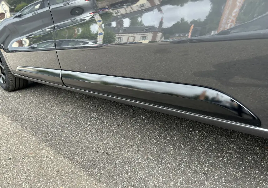 Gros plan sur la partie basse côté gauche du Citroën Jumpy Fourgon gris acier, mettant en valeur la protection latérale noire.