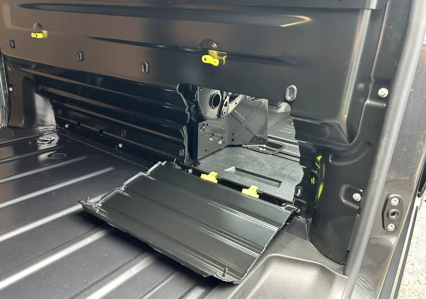 Détail intérieur du compartiment de chargement arrière du Citroën Jumpy Fourgon gris acier, avec trappe ouverte et fixations jaunes visibles.