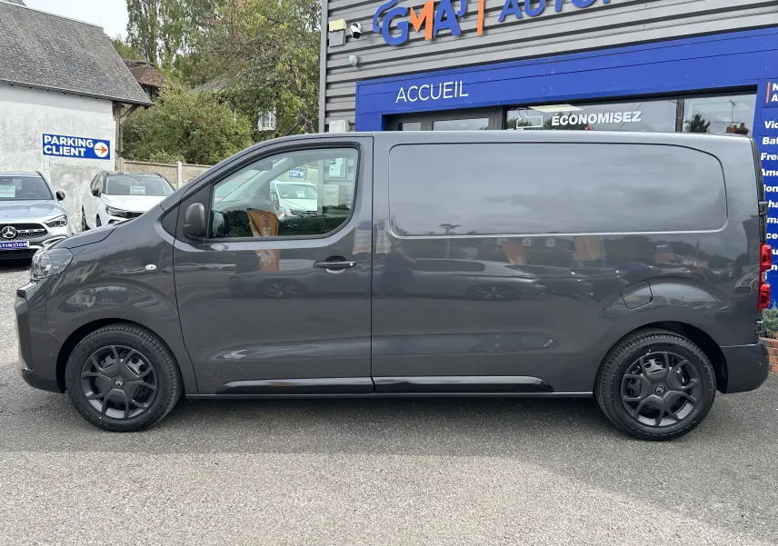Vue de profil côté gauche d'un Citroën Jumpy Fourgon gris acier avec jantes noires et carrosserie lisse.