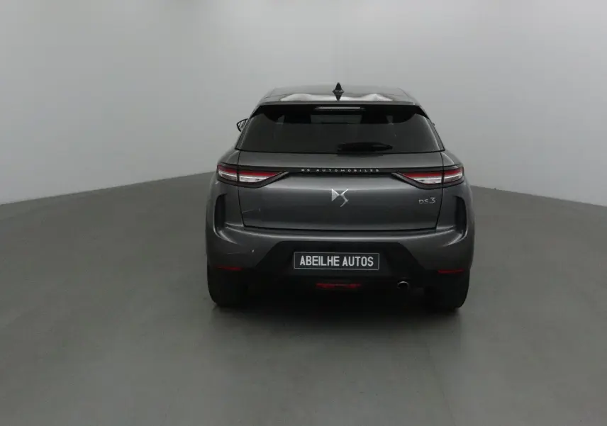 Vue arrière d'un DS3 Crossback gris platinium 2024 avec feux LED et logo DS visible sur fond neutre.