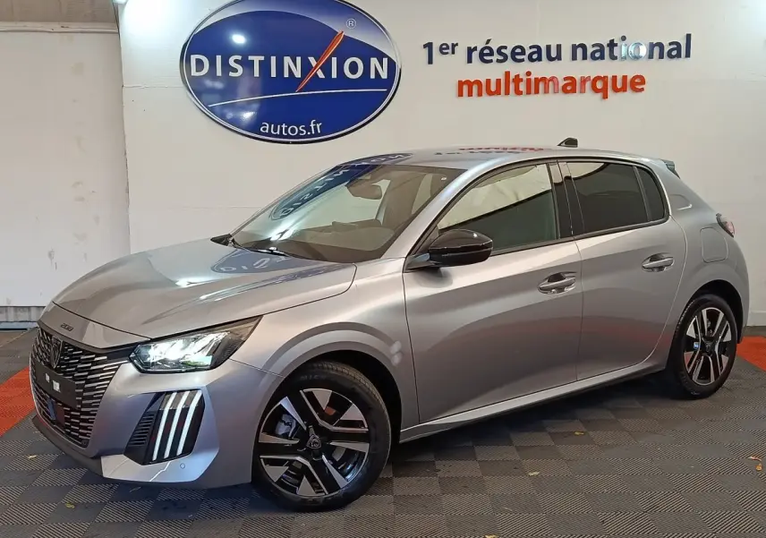 Peugeot 208 gris clair vue 3/4 avant droit, avec phares LED et jantes alliage distinctives.