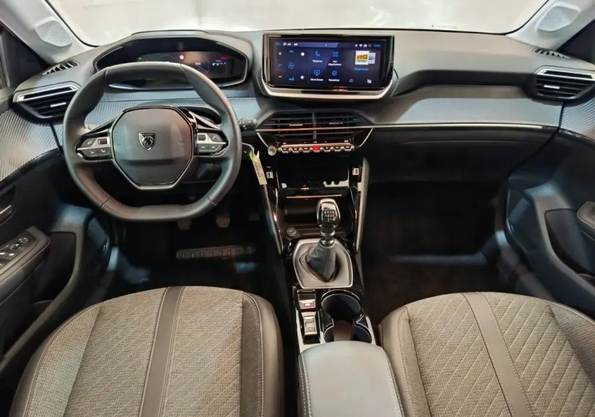 Intérieur Peugeot 208 PureTech 100 S&S Allure 2025, vue avant centrée sur volant cuir et écran tactile central.