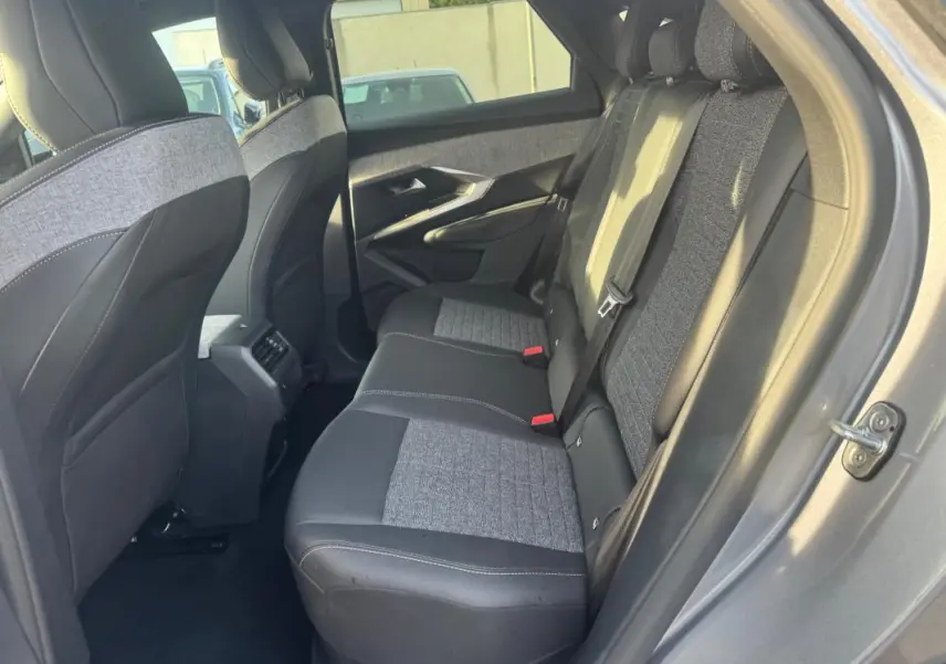 Vue côté droit de l'intérieur arrière gris du Peugeot 3008 Hybrid 145 e-DCS6 Allure avec sièges tissu et cuir bicolores.