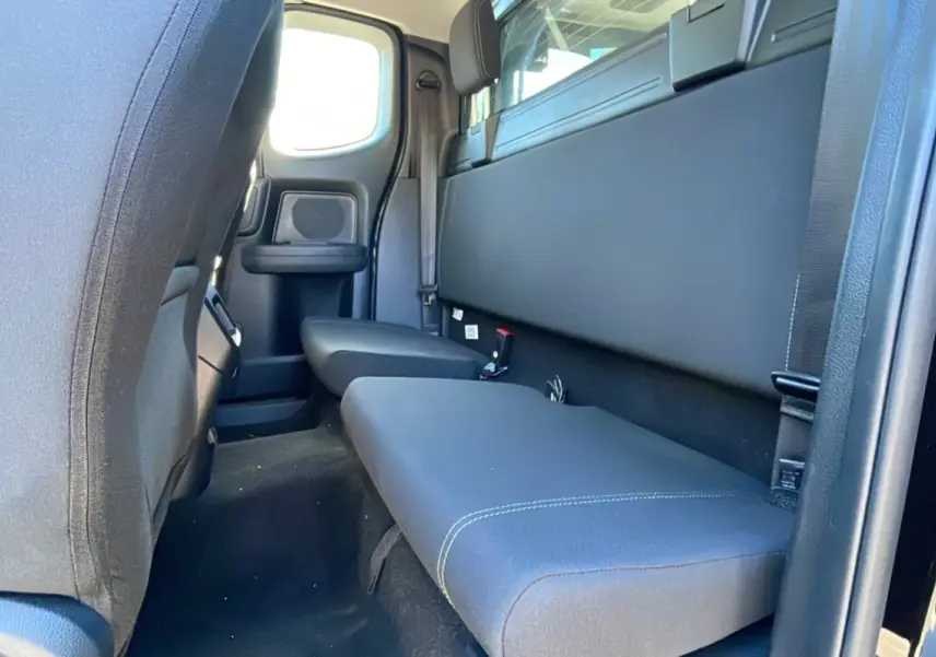 Vue intérieure arrière côté droit du Ford Ranger noir shadow avec banquette et fenêtre de cabine arrière.