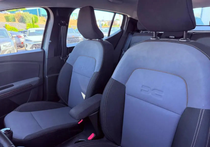 Vue intérieure côté avant droit des sièges tissu brun cuivré avec logo Extreme embossé sur une Dacia Sandero 2025.