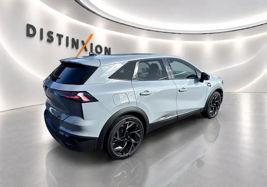 Vue 3/4 arrière droite du Renault Symbioz gris rafale avec jantes noires et feux arrière LED dans un showroom lumineux.