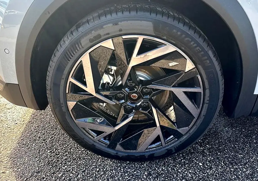 Gros plan sur la roue avant droite du Renault Symbioz gris rafale, mettant en valeur la jante alu au design géométrique noir et argent.