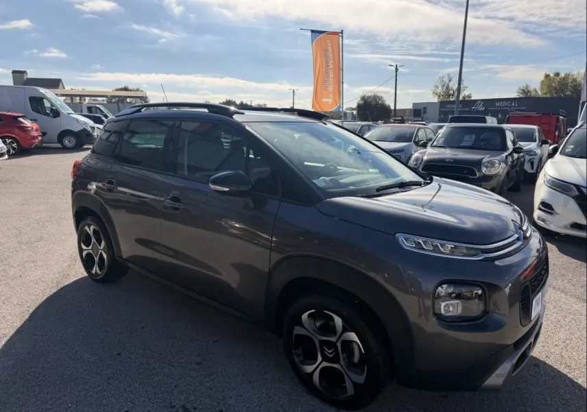 Citroën C3 Aircross gris métal vue 3/4 avant droit, avec jantes distinctives et toit noir contrasté.