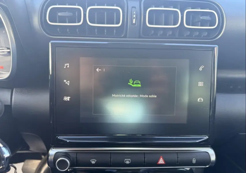 Vue rapprochée de l’écran tactile central et des aérateurs du tableau de bord noir du Citroën C3 Aircross 2021 gris métal.
