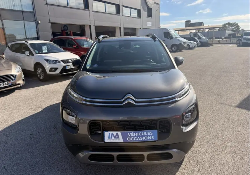 Citroën C3 Aircross gris métal vue de face, avec calandre distinctive et plaque "Véhicules Occasions" visible.