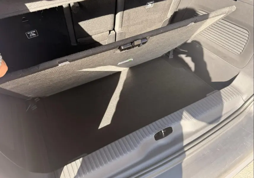 Vue rapprochée du coffre ouvert du Citroën C3 Aircross gris métal 2021, montrant le compartiment de rangement sous plancher.