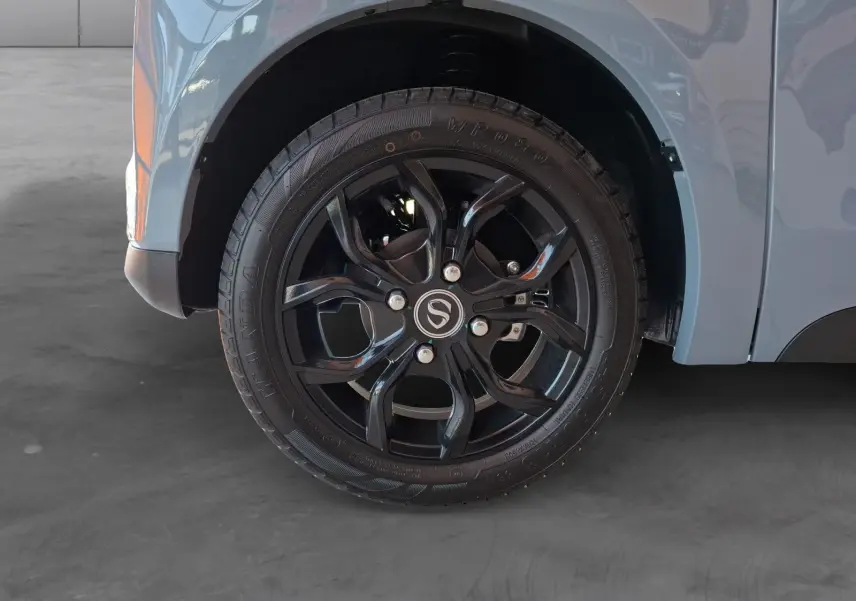 Gros plan sur la roue avant droite noire avec jante en alliage du SIMPLICI S1 gris perle au toit noir.