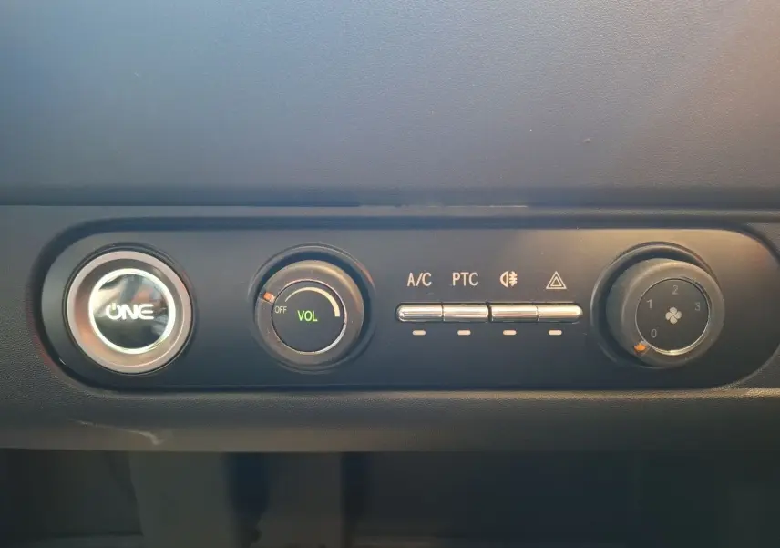 Gros plan sur la console centrale du SIMPLICI S1 gris perle 2025, avec commandes de climatisation et volume.