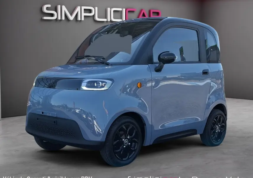 Vue 3/4 avant droite de la SIMPLICI S1 électrique 2025 gris perle avec toit noir et jantes noires brillantes.