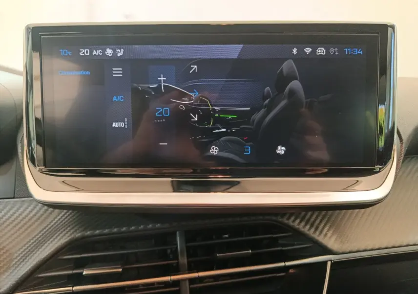 Écran tactile central affichant la climatisation à 20°C dans l'habitacle d'une Peugeot 208 gris foncé.