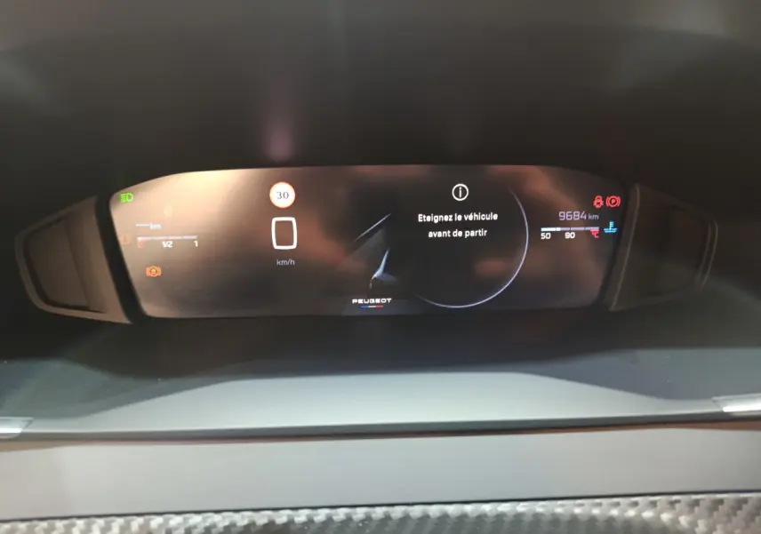 Affichage numérique du combiné d'instruments de la Peugeot 208 PureTech 100 S&S Allure avec message d'alerte et kilométrage visible.