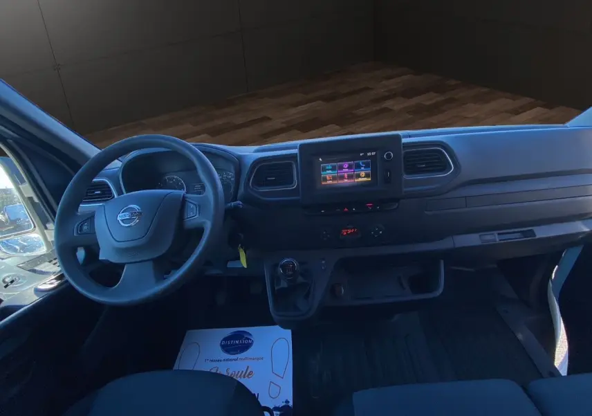 Vue intérieure du poste de conduite du Nissan Interstar blanc, avec tableau de bord moderne et écran tactile central.