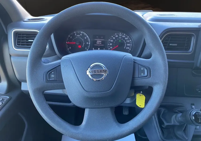 Vue intérieure centrée sur le volant noir du Nissan Interstar 2022 avec tableau de bord et levier de vitesses manuel.