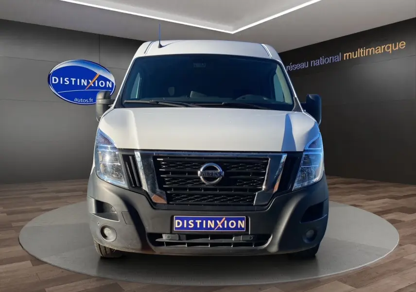 Vue frontale d’un utilitaire Nissan Interstar blanc avec calandre noire et pare-chocs avant noir mat dans un showroom.