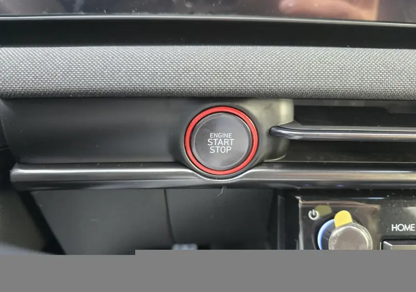 Gros plan sur le bouton start/stop entouré de rouge dans l’habitacle noir du Hyundai Tucson 2025.