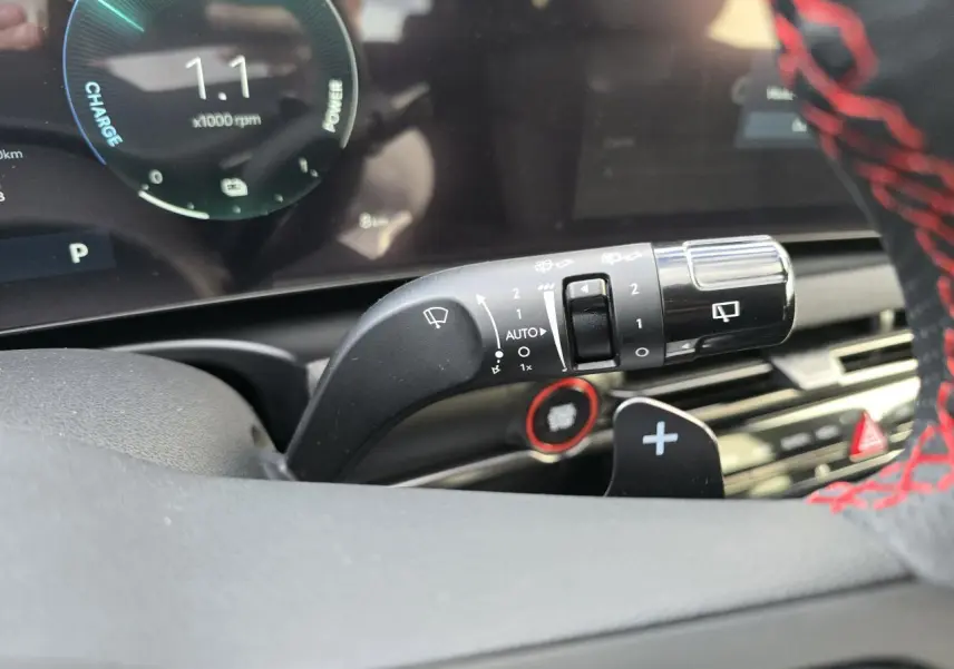 Gros plan sur la manette d’essuie-glace du Hyundai Tucson N Line 2025, volant cuir noir avec surpiqûres rouges visible.