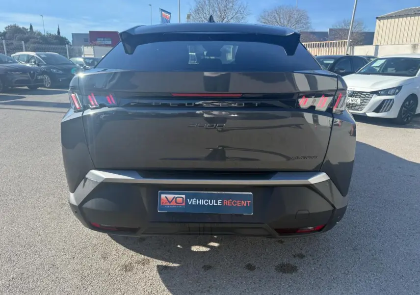 Vue arrière d’un Peugeot 3008 Hybrid gris 2025 avec feux arrière à griffes et plaque VÉHICULE RÉCENT.