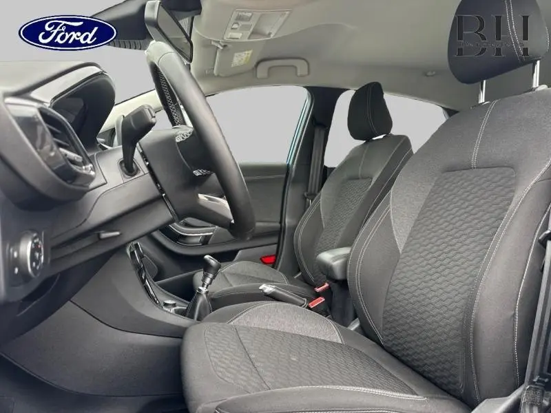 Vue intérieure côté gauche du Ford Puma 2023, sièges tissu noir Kasbah et volant avec levier de vitesses manuel visible.