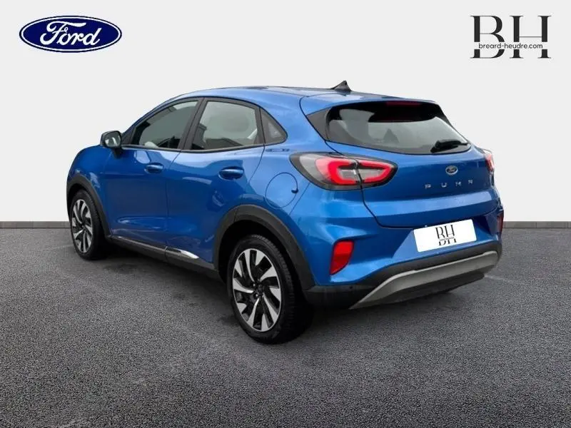 Vue 3/4 arrière droite d'une Ford Puma 2023 bleu Fashion Island métallisé avec jantes alliage et feux arrière LED.
