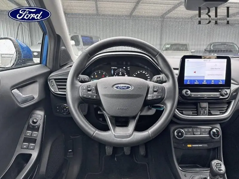 Vue intérieure frontale du poste de conduite du Ford Puma 2023 avec volant multifonction et écran tactile central.