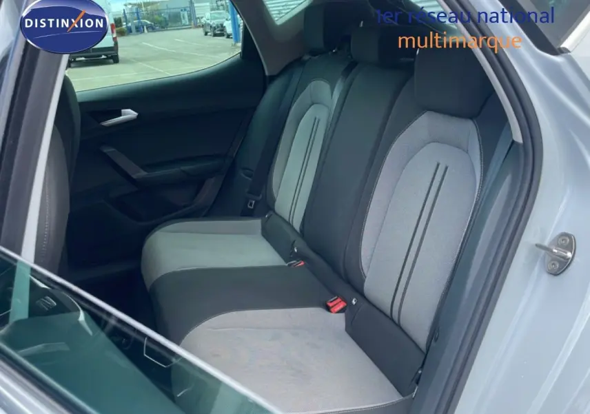 Vue intérieure côté droit montrant la banquette arrière gris clair et noir du SEAT LEON blanc neige métal 2025.