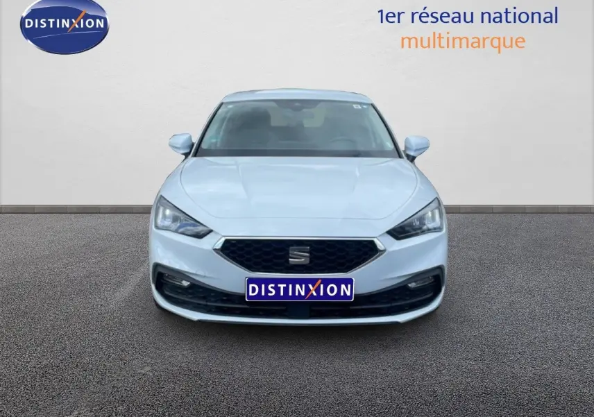 Vue frontale d'une SEAT Leon 2.0 TDI blanche neige métal avec calandre hexagonale et phares LED distinctifs.