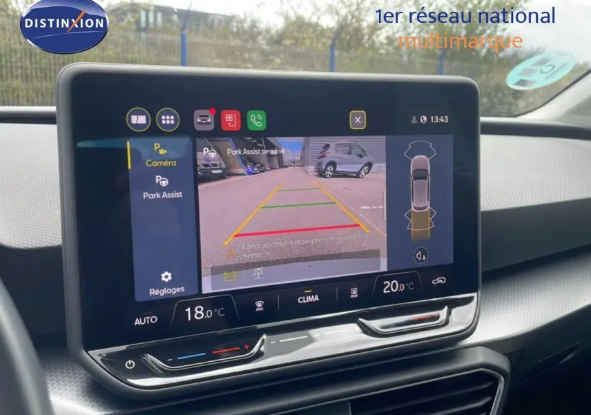 Écran tactile central affichant la caméra de recul et l'assistance au stationnement dans l'habitacle d'une SEAT Leon blanche.