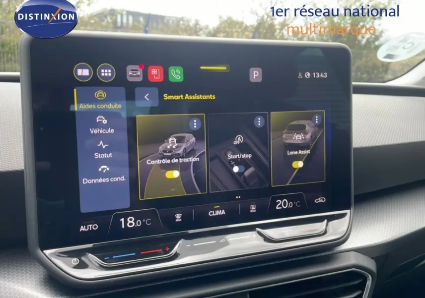 Vue intérieure centrée sur l'écran tactile du tableau de bord du SEAT LEON blanc neige, affichant les assistants de conduite.