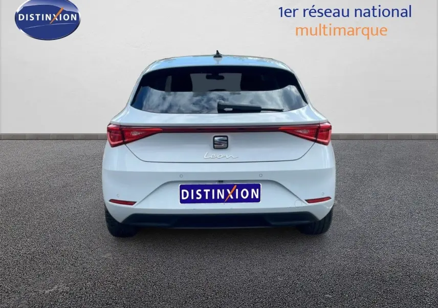 Vue arrière d'une SEAT Leon 2025 blanche neige métal, avec feux arrière LED et vitre arrière teintée.