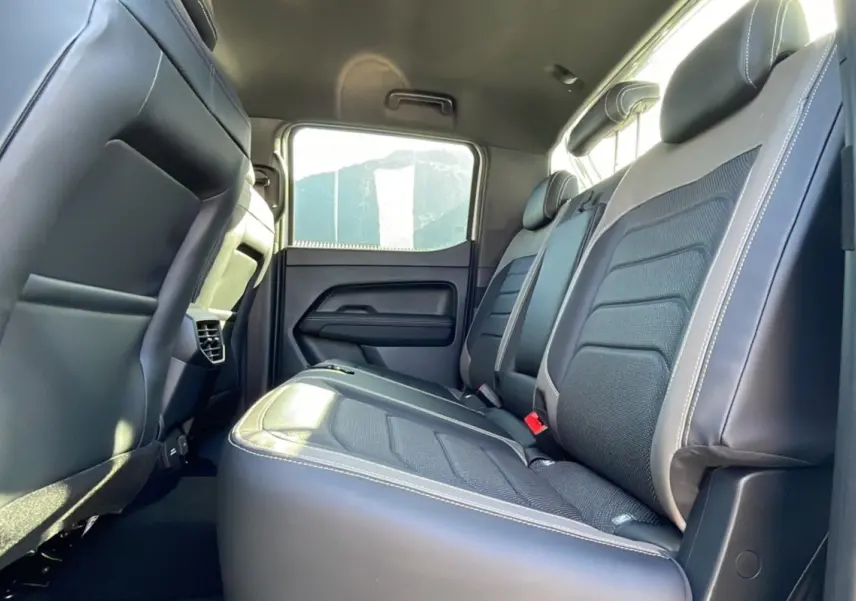 Vue intérieure côté droit des sièges arrière en cuir noir du Volkswagen Amarok Simple Cabine V6 blanc 2026.